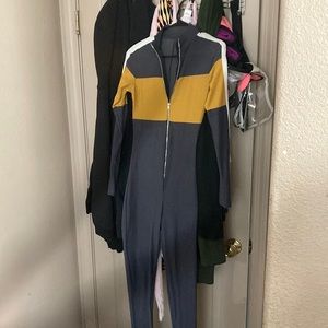 A jumpsuit that is gold white and grey and a size small